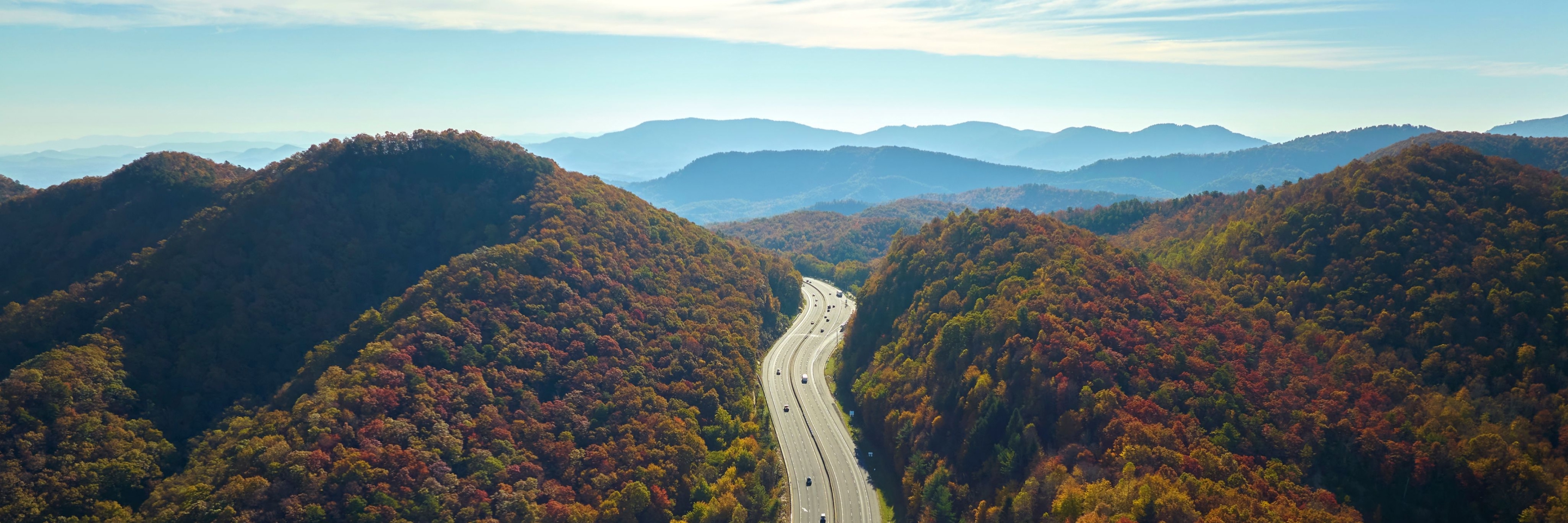 Highway running through forested mountains in autumn