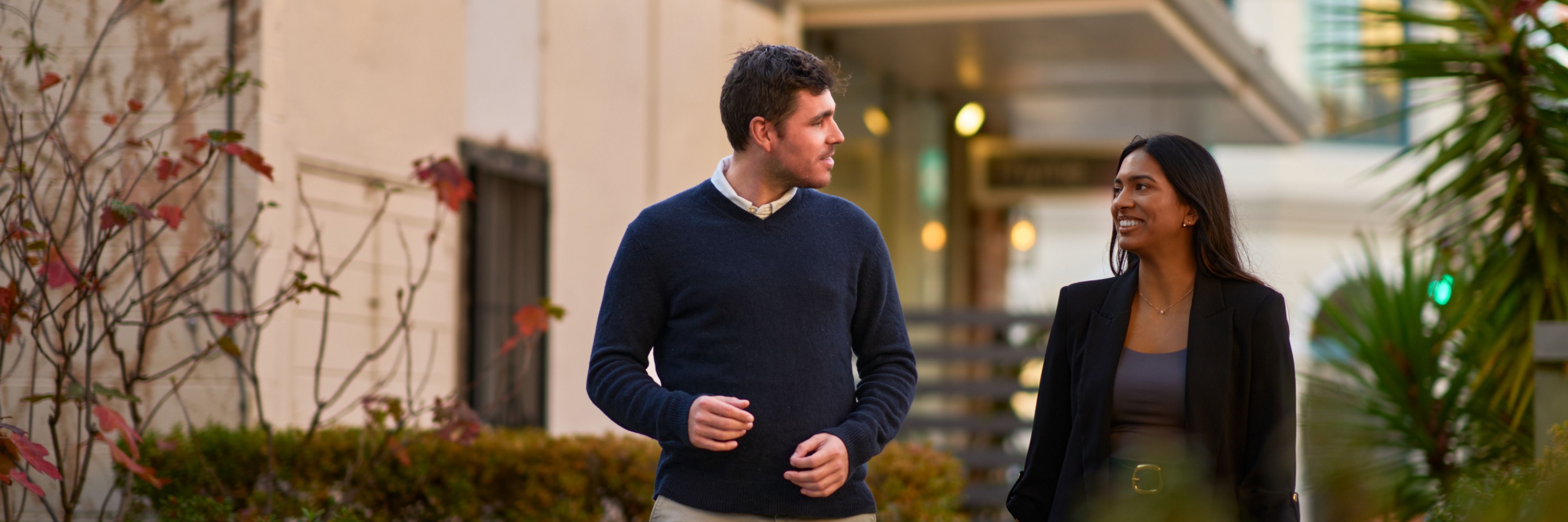 Two professionals walking and talking outside an office building